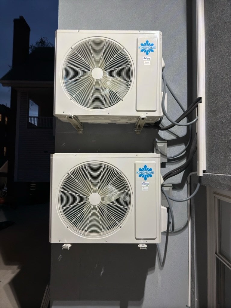 Two stacked Kinghome mini-split outdoor units on a residential building
